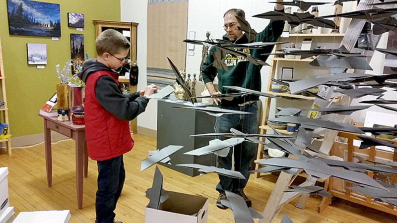 Justin adjusted each falcon beak before it was hoisted up! Dad looks on.
