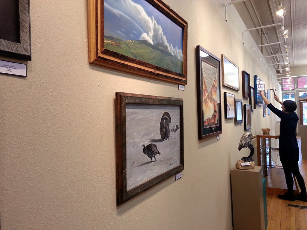 Ava is busy hanging the Winter Art Show.