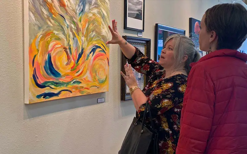 artists looking at art on wall